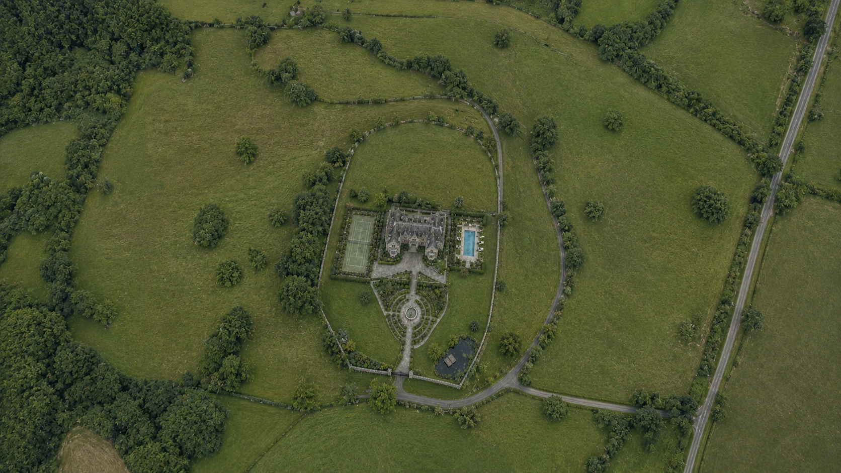 Overhead view of the protected estate: the house and walled gardens at the centre of open parkland. A monitored perimeter runs out at the field boundary carrying metal, vibration, acoustic, radar, gas and radioactivity sensors, with an inner ring of cameras and FLIR closer to the house